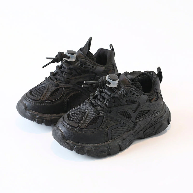 Zwarte chunky kinderscneakers met diepe zool en elastische veters, beide paren zichtbaar